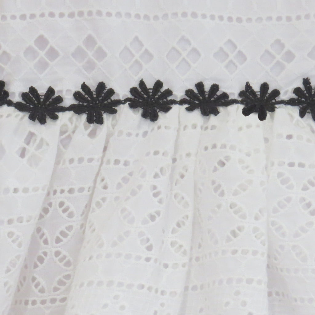 Childs Summer white cotton broderie anglaise dress with black daisy trim.