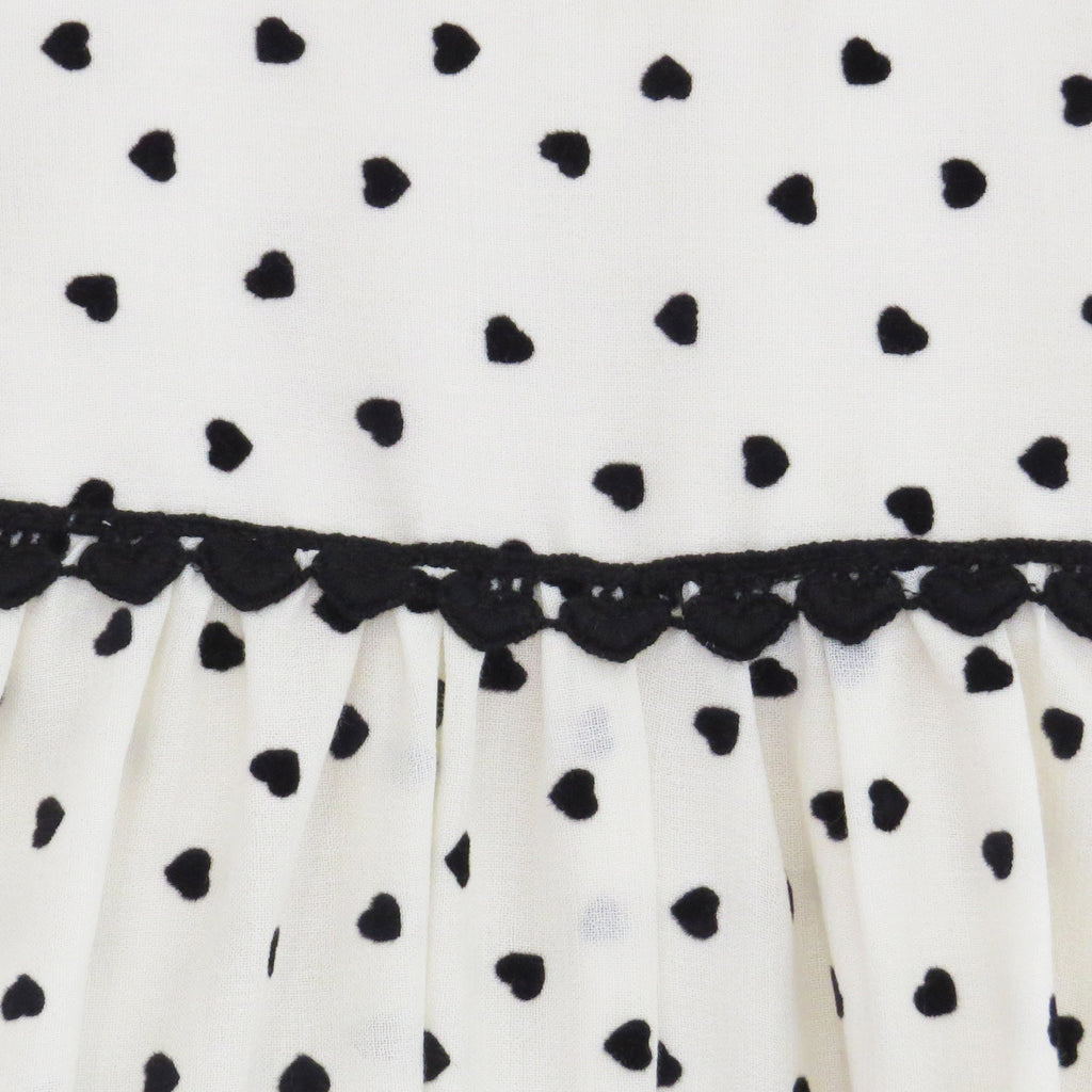 Summer Childs cream and black heart print dress fabric close up.