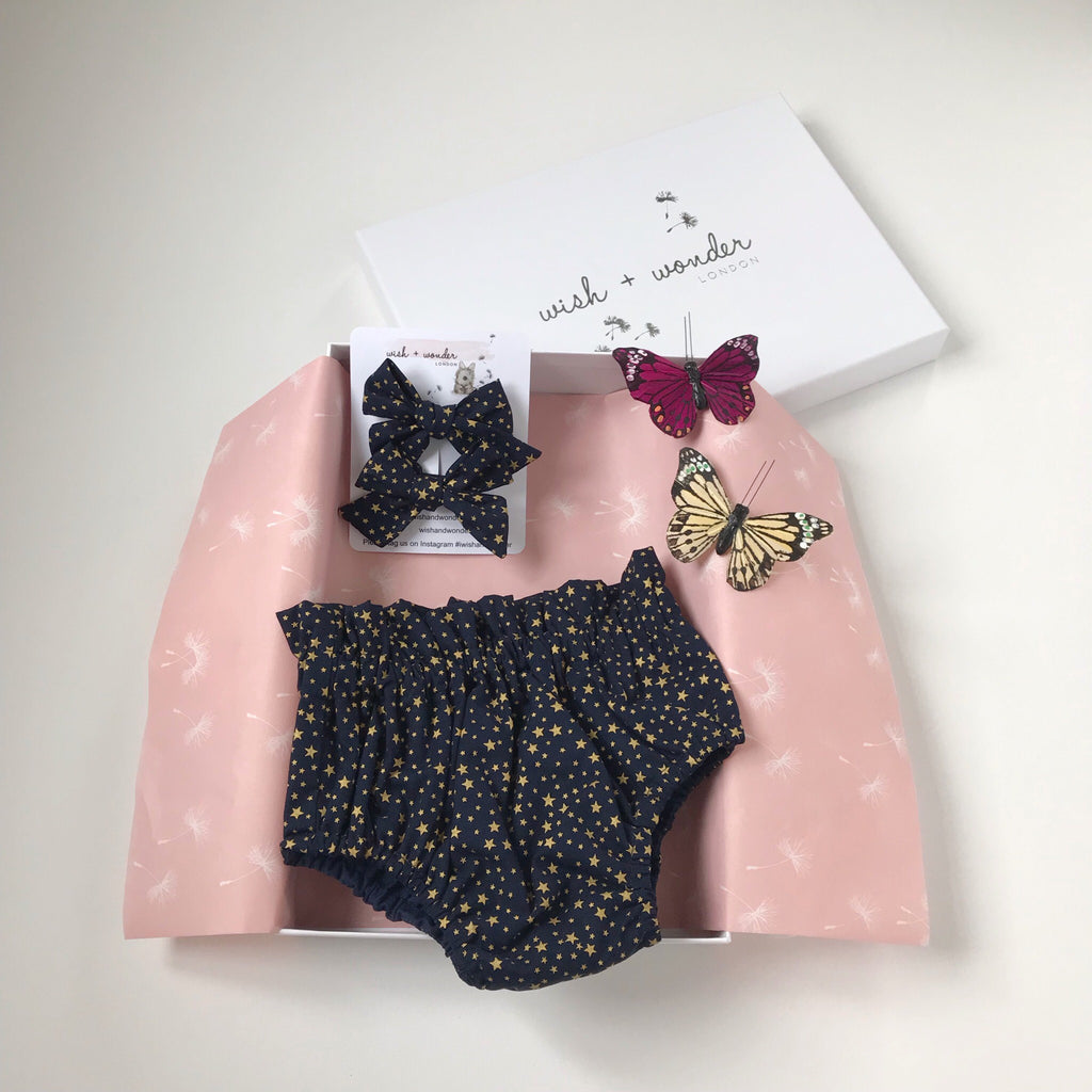 Baby and Toddler high waisted bloomer shorts and matching hair bow set in gold star print on midnight blue ground.