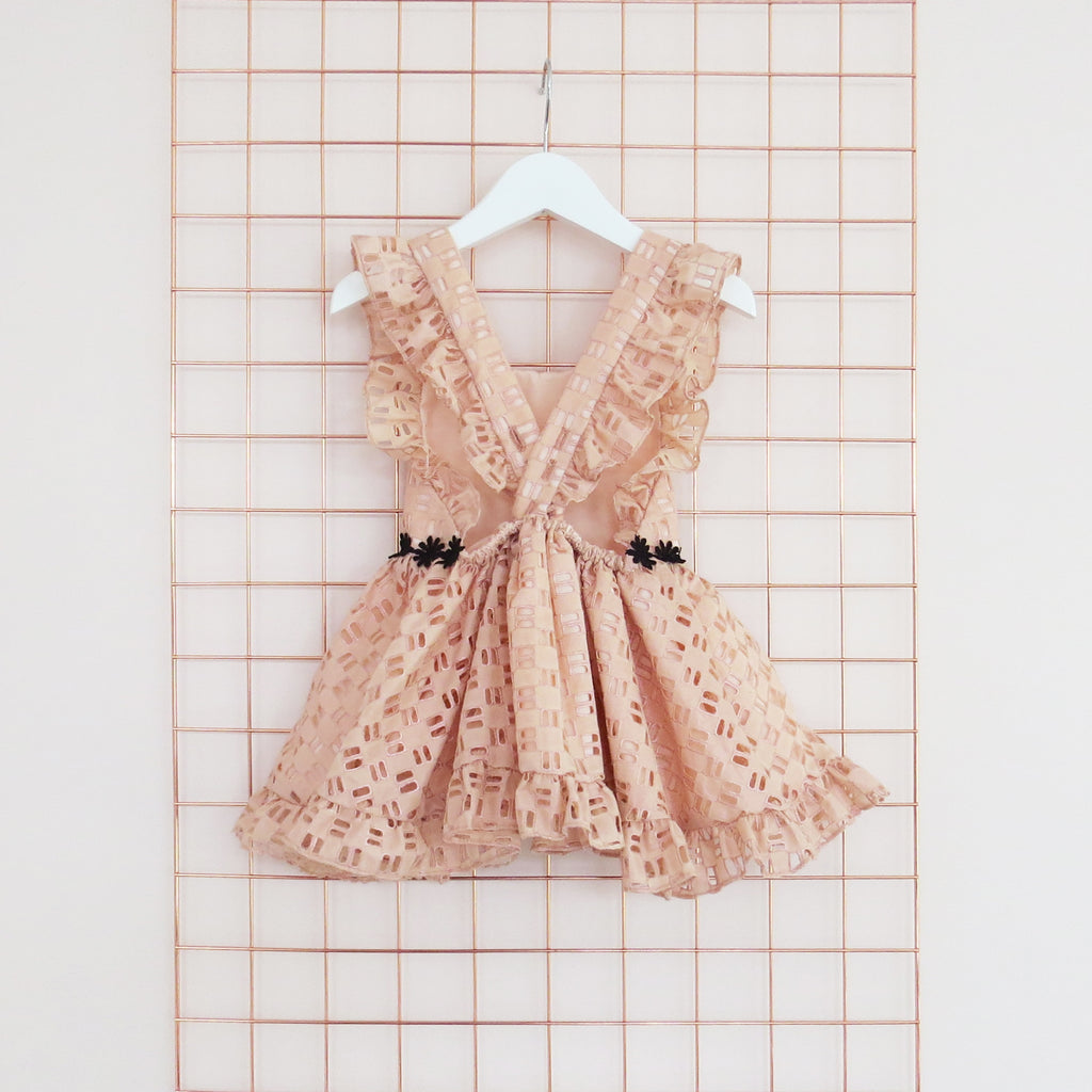 Childs Summer peach cotton geometric broderie anglaise dress with black daisy trim, rose gold foil and frill sleeves.