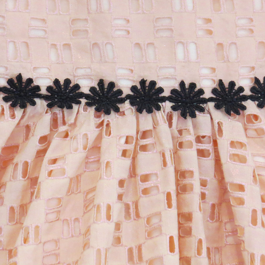 Childs Summer peach cotton geometric broderie anglaise dress with black daisy trim, rose gold foil fabric close up.