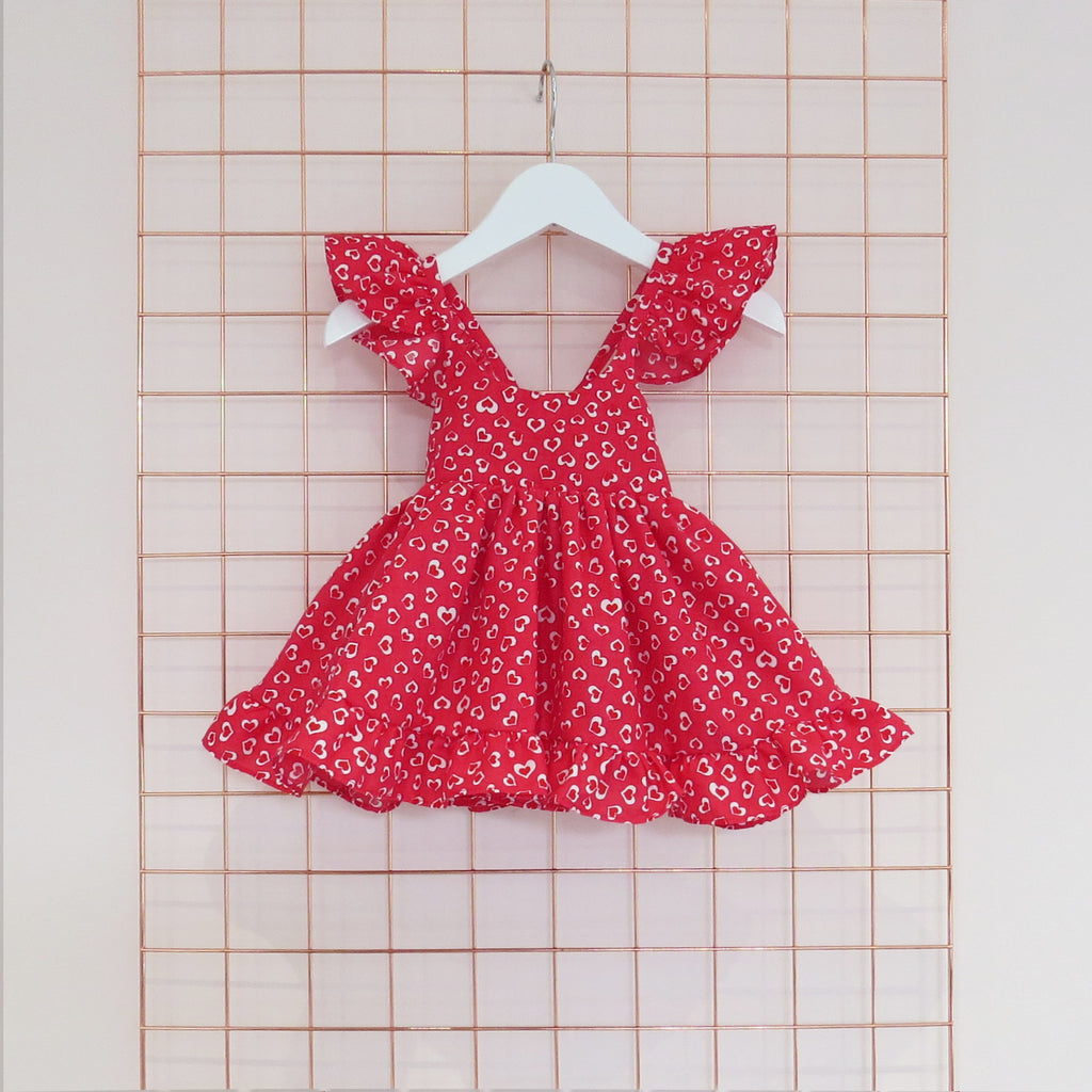 Childs Summer red conversational heart print dress in bright red and white with frill sleeves.